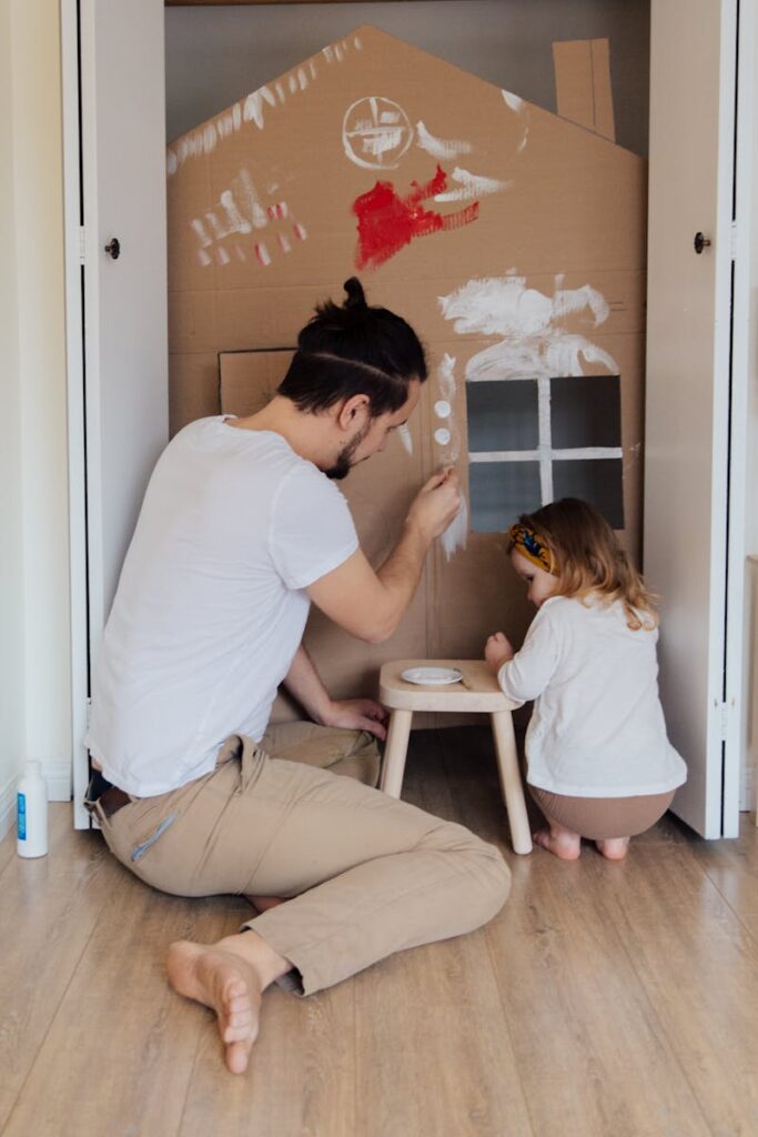 Father and Daughter Painting a Cardboard House Together and parenting in a new age